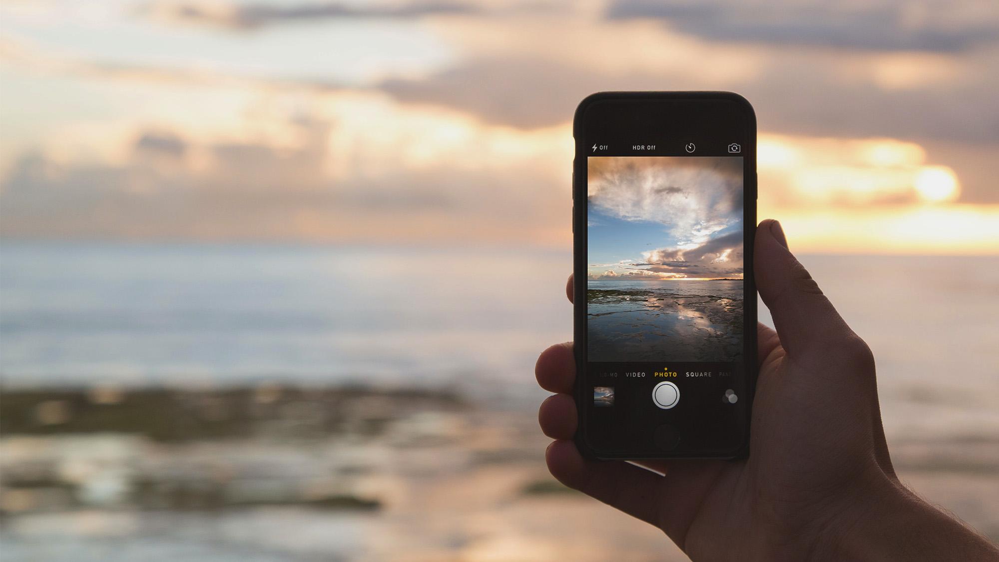 Kännykkäkamera kuvaa merimaisemaa auringonlaskussa