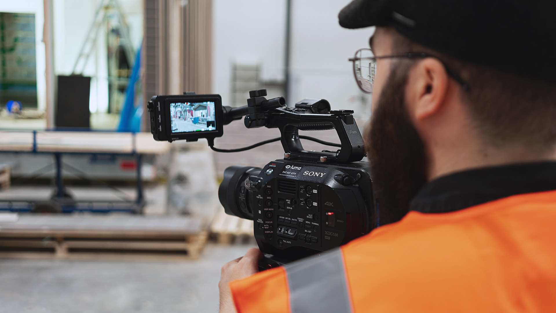 Videokuvaaja operoi kameraa tehtaassa